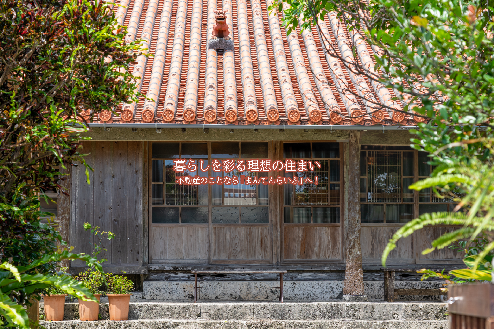赤瓦屋根の上にシーサーが設置されている沖縄のお家の画像